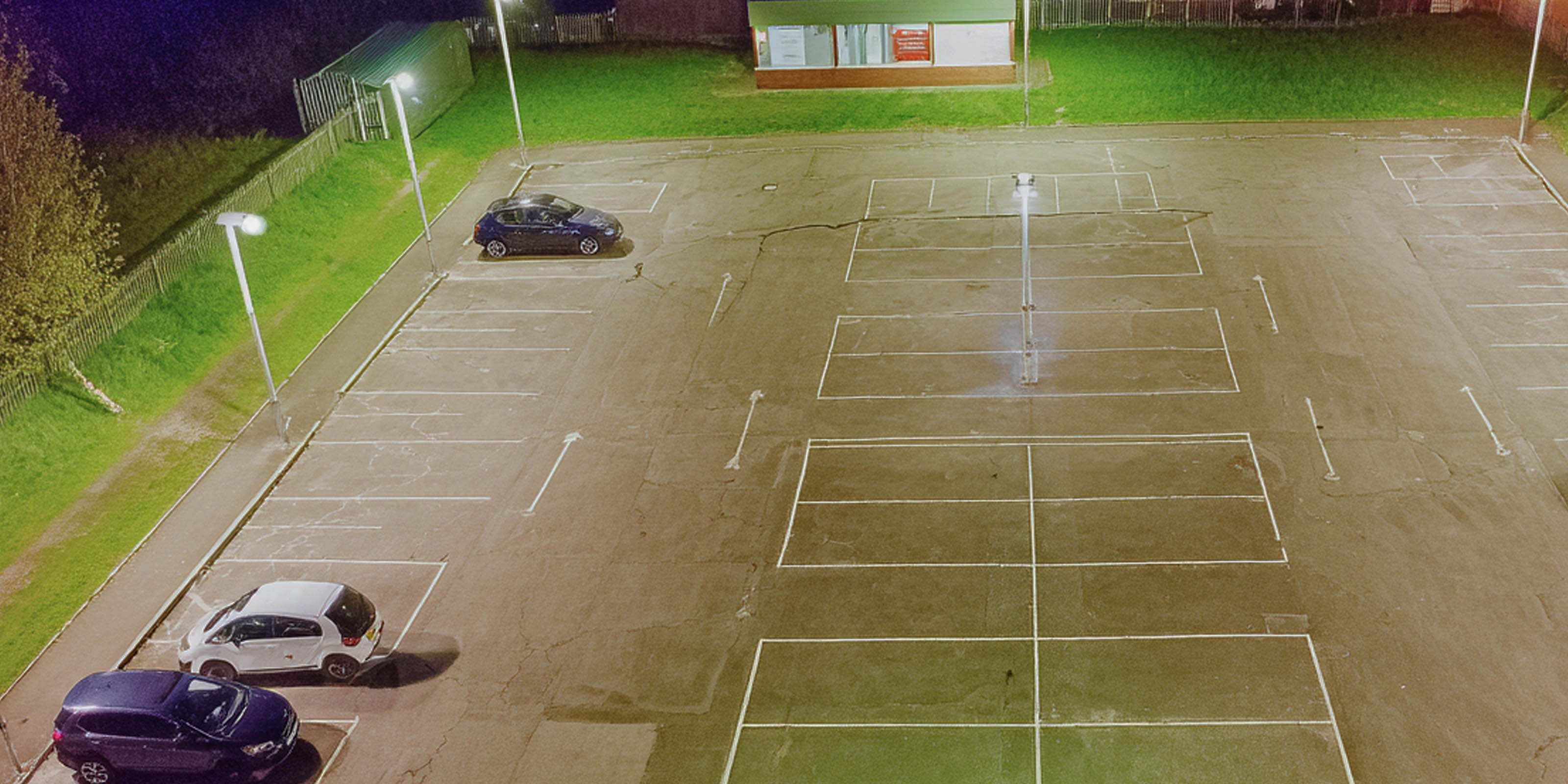 Modern car park at night lit by LED street lighting, providing bright and uniform illumination for safety and visibility.