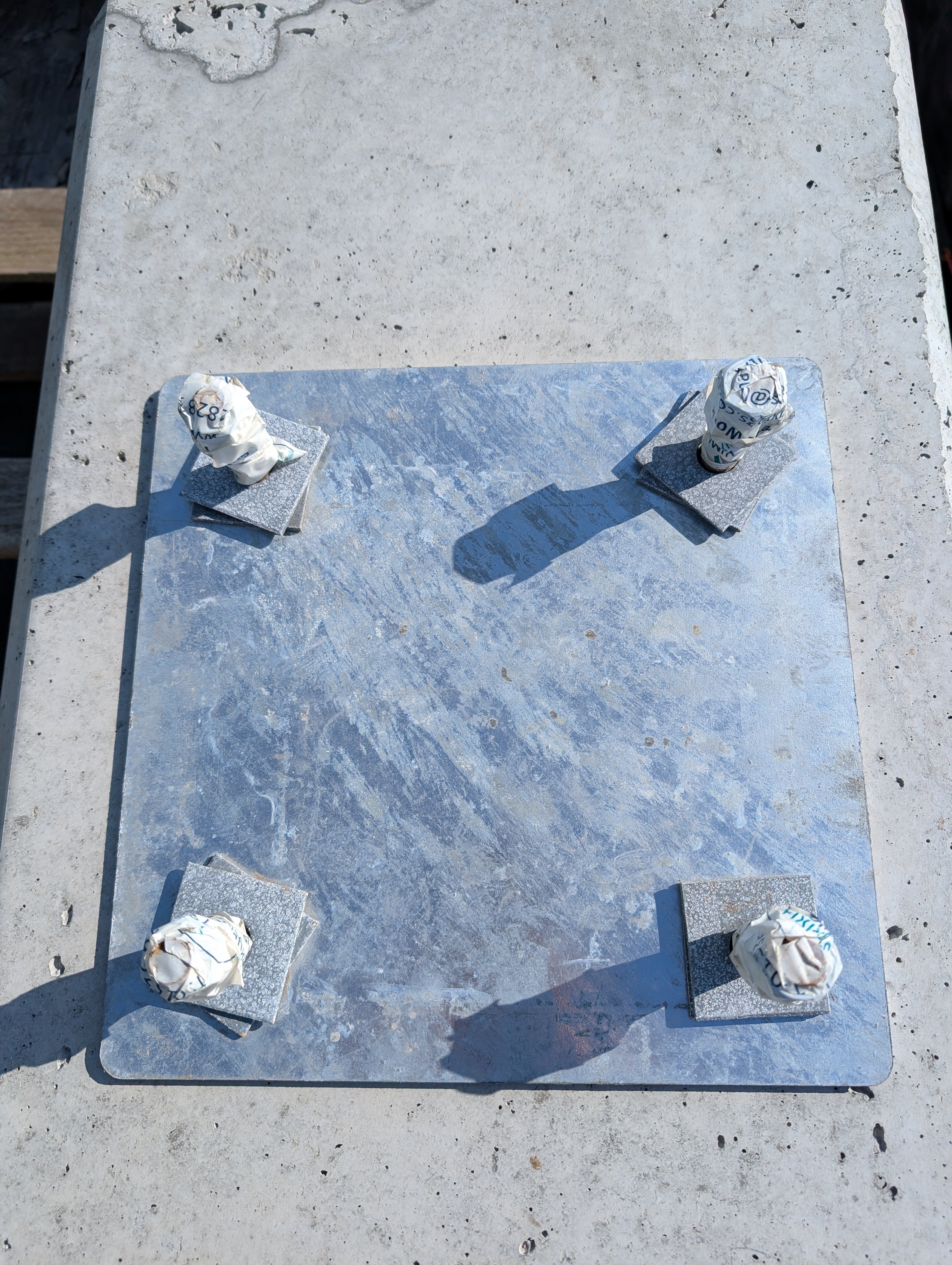 Galvanised steel base plate with 16mm high tensile rods at 200mm centres, set in a custom steel frame for secure column foundation support.