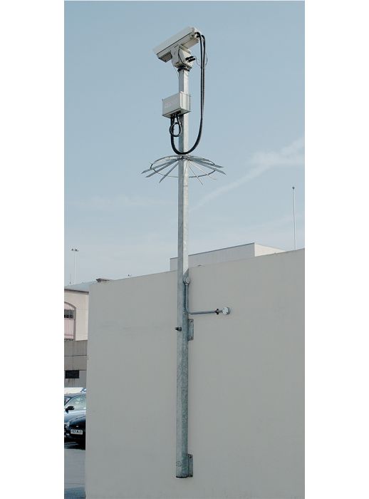 Wall-mounted CCTV pole with anti-climb guard, supporting surveillance camera and control box, ideal for perimeter or car park security installations.